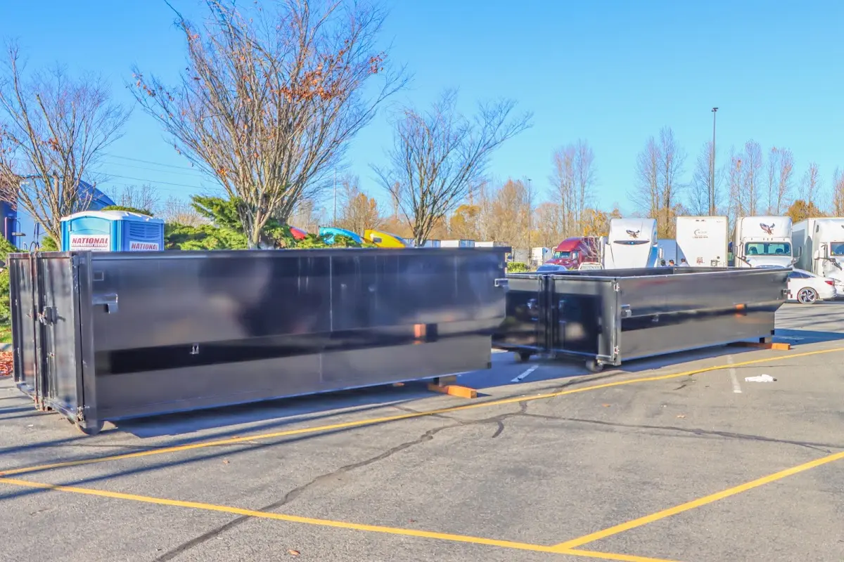 Professional dumpster rental service with roll-off container on residential driveway in Henniker